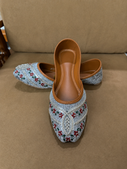 Decorative shoes with floral patterns on a brown surface